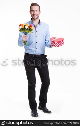 Portrait of happy young man with flowers and a gift - isolated on white.