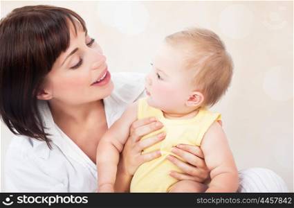 Portrait of happy young mother with cute little daughter on blur background, beautiful woman enjoying parenthood, family love concept