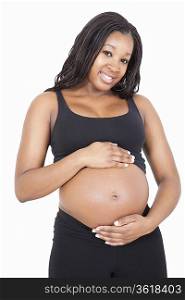 Portrait of happy young pregnant woman with hands on stomach over white background