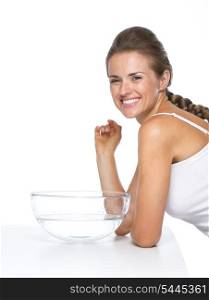 Portrait of happy young woman and glass bowl with water