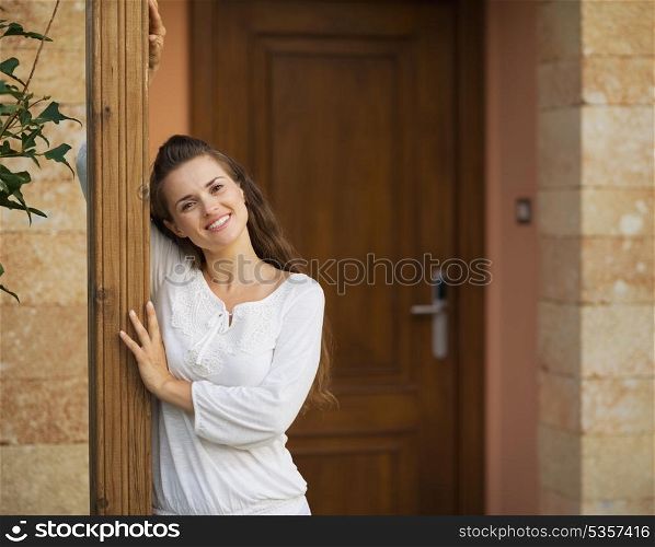 Portrait of happy young woman at doorstep