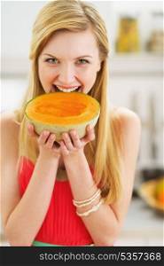 Portrait of happy young woman biting melon