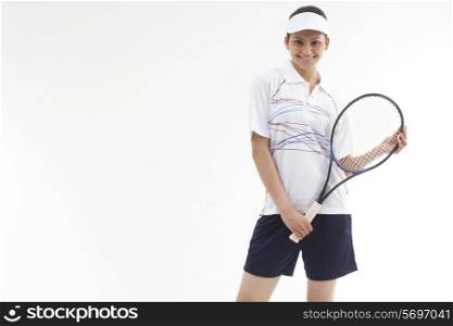 Portrait of happy young woman holding tennis racket isolated over gray background