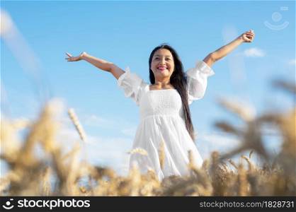 Portrait of happy young woman in a white dress, on a wheat field. Lifestyle and happiness concept. Woman with open arms . High quality photo. Portrait of happy young woman in a white dress, on a wheat field. Lifestyle and happiness concept. Woman with open arms .