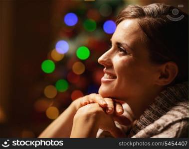 Portrait of happy young woman in front of christmas lights