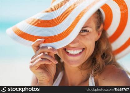 Portrait of happy young woman in swimsuit and beach hat