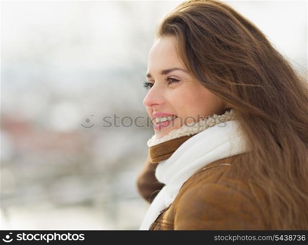 Portrait of happy young woman looking on copy space in winter outdoors