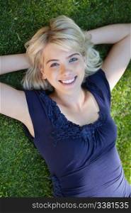 Portrait of happy young woman lying on grass