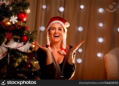 Portrait of happy young woman near Christmas tree&#xA;