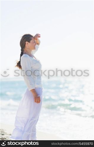Portrait of happy young woman on sea shore looking into distance