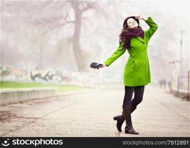 Portrait of Happy Young Woman Standing at the Walkway in the Foggy Autumn Day