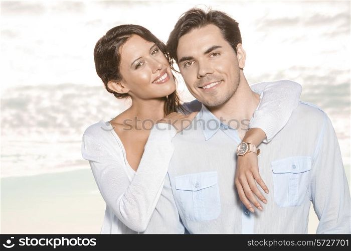 Portrait of happy young woman with arm around man at beach