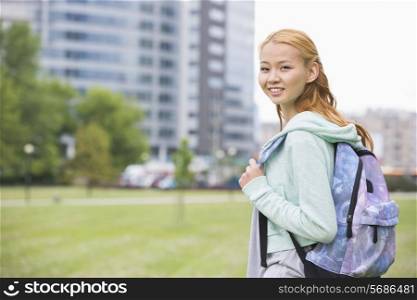 Portrait of happy young woman with backpack at college campus