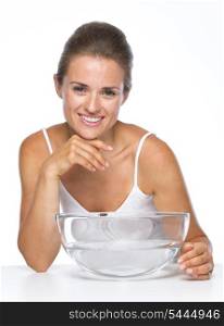 Portrait of happy young woman with glass bowl with water