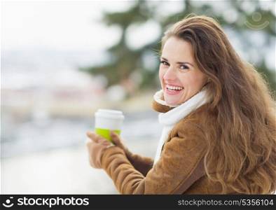 Portrait of happy young woman with hot beverage