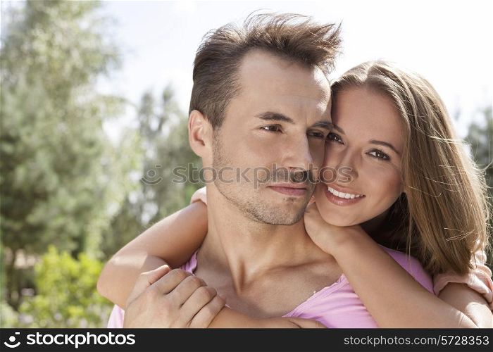 Portrait of happy young woman with man in park