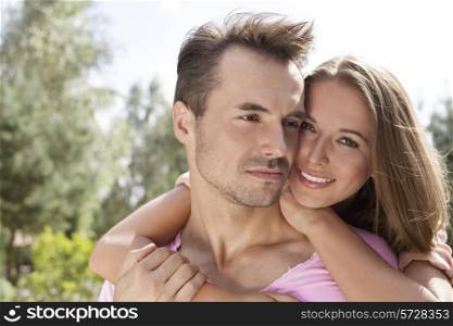 Portrait of happy young woman with man in park