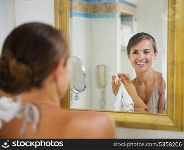 Portrait of happy young woman with towel in bathroom