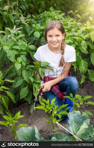 Portrait of happy young woman working at garden with trowel