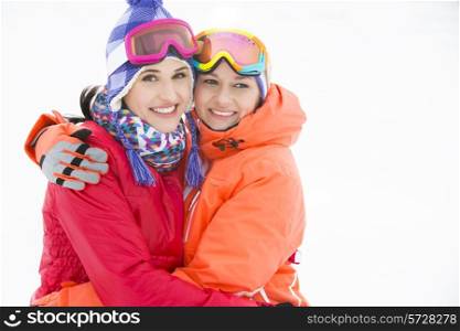 Portrait of happy young women in warm clothing embracing outdoors