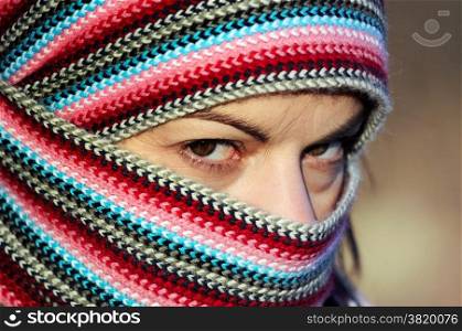 Portrait of hard looking young woman in motley head scarf close up