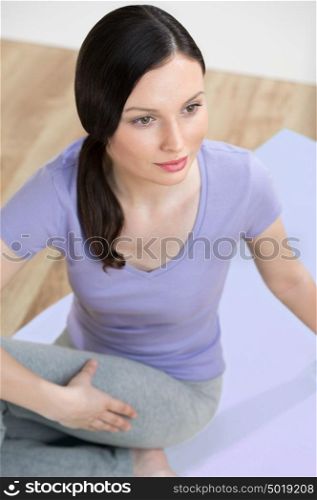 Portrait of healthy young lady practising yoga exercise - Spine twisting pose