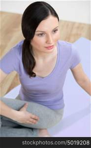 Portrait of healthy young lady practising yoga exercise - Spine twisting pose