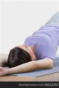 Portrait of healthy young woman practising yoga exercise on mat at home