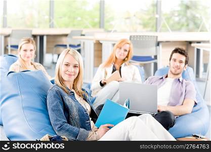 Portrait of high-school study group with laptop sitting together
