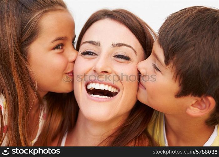Portrait Of Hispanic Children Kissing Mother