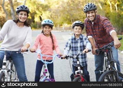 Portrait Of Hispanic Family On Cycle Ride In Countryside