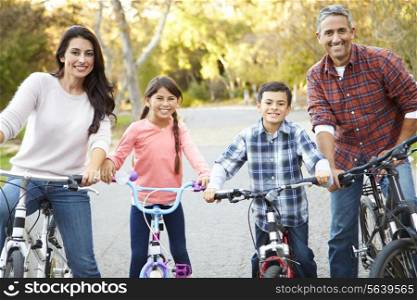 Portrait Of Hispanic Family On Cycle Ride In Countryside