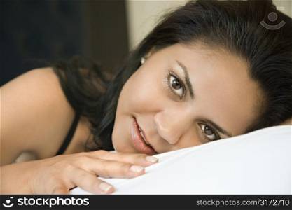 Portrait of Hispanic young adult woman lying down.