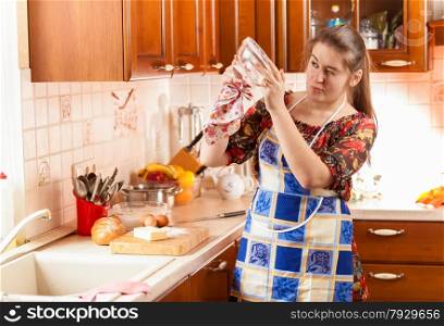 Portrait of housewife checking how clean is the glass bowl