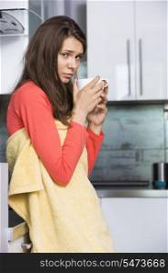 Portrait of ill woman having coffee in kitchen