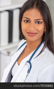 Portrait of Indian Asian female medical doctor in a hospital office happy and smiling with stethoscope