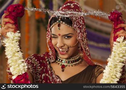 Portrait of Indian bride holding a garland