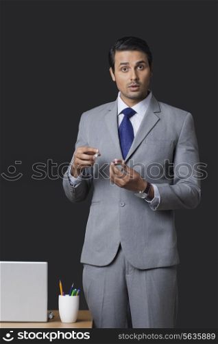Portrait of Indian businessman holding lip balm pot in office