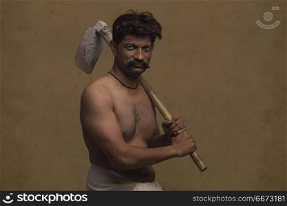 Portrait of Indian farmer carrying hoe on his shoulder