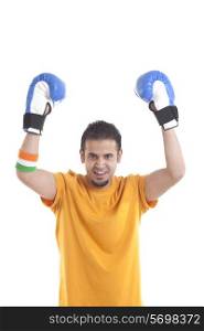 Portrait of Indian male young boxing player with arms up isolated over white background