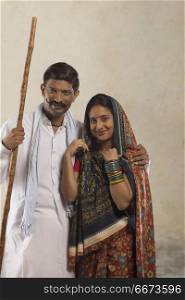 Portrait of Indian rural couple holding stick