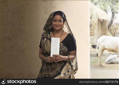 Portrait of Indian rural woman holding bank cheque