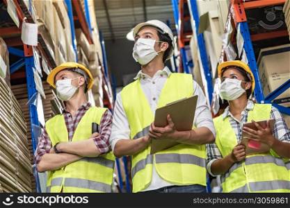 Portrait of Interracial group Asian African and Caucasian with clipboard and barcode scanner wear face mask to prevent COVID-19 coronavirus infection in distribution center. Business teamwork concept.