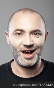 portrait of ironical smiling man isolated on gray background