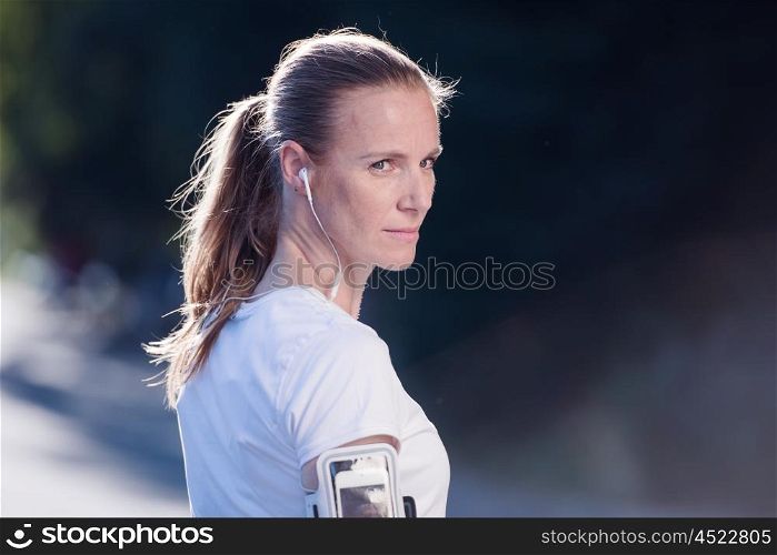 portrait of jogging woman before running on early morning with sunrise in background
