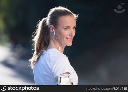 portrait of jogging woman before running on early morning with sunrise in background