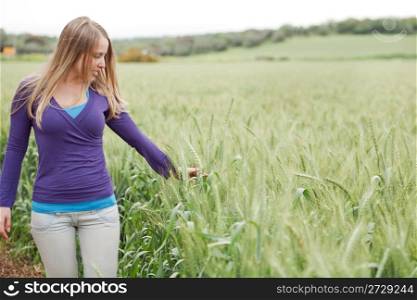 Portrait of lady walking between the grass in the field