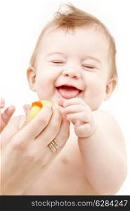portrait of laughing baby boy in mother hands playing with rubber duck