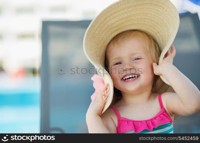 Portrait of laughing baby in beach hat