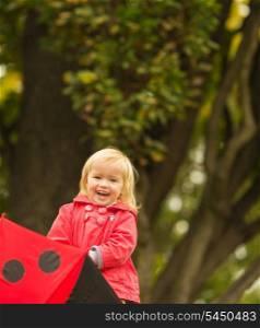 Portrait of laughing baby with red umbrella
